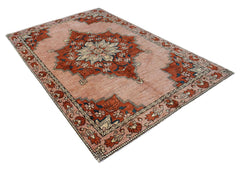 Handmade Afghan Kohi wool rug featuring a central floral medallion on a dusty pink background.