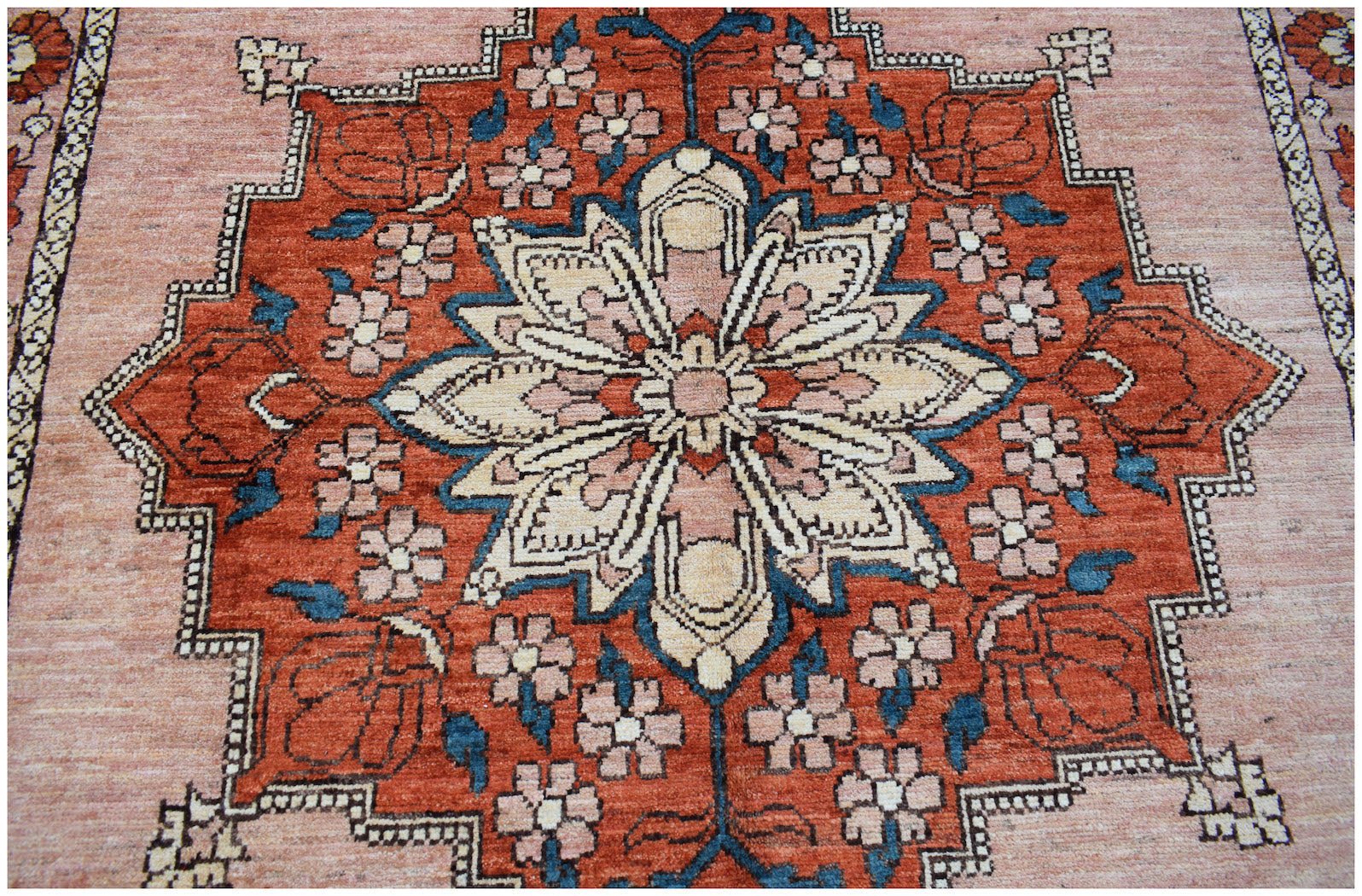 Handmade Afghan Kohi wool rug featuring a central floral medallion in rust, cream, and blue tones.