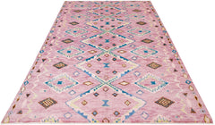 A handmade Afghan wool rug featuring a pink field with a repeating blue and cream diamond pattern.