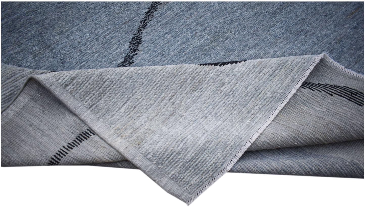 A hand-knotted Afghan Kohi rug in blue wool with a black abstract line pattern.