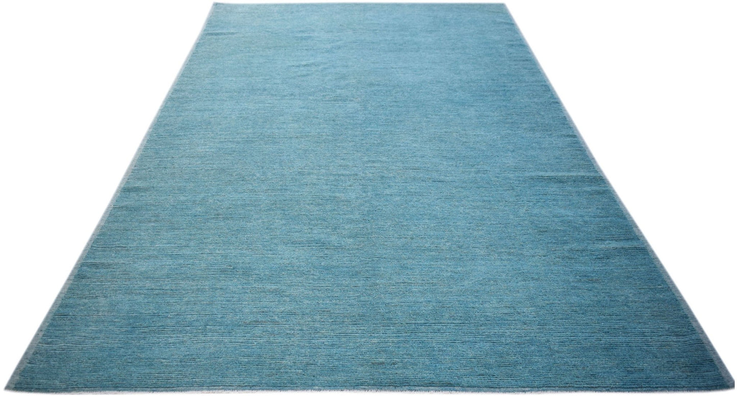 A rectangular, hand-knotted Afghan Kohi rug in a solid, textured blue wool.