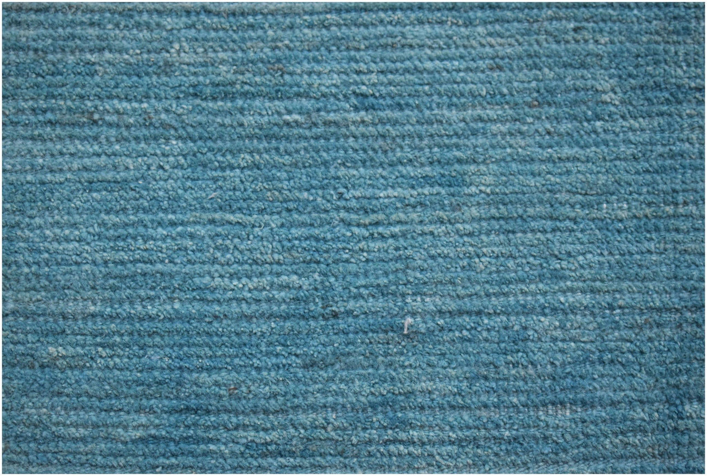 A hand-knotted Afghan Kohi rug featuring a textured, ribbed surface in a solid teal blue tone.