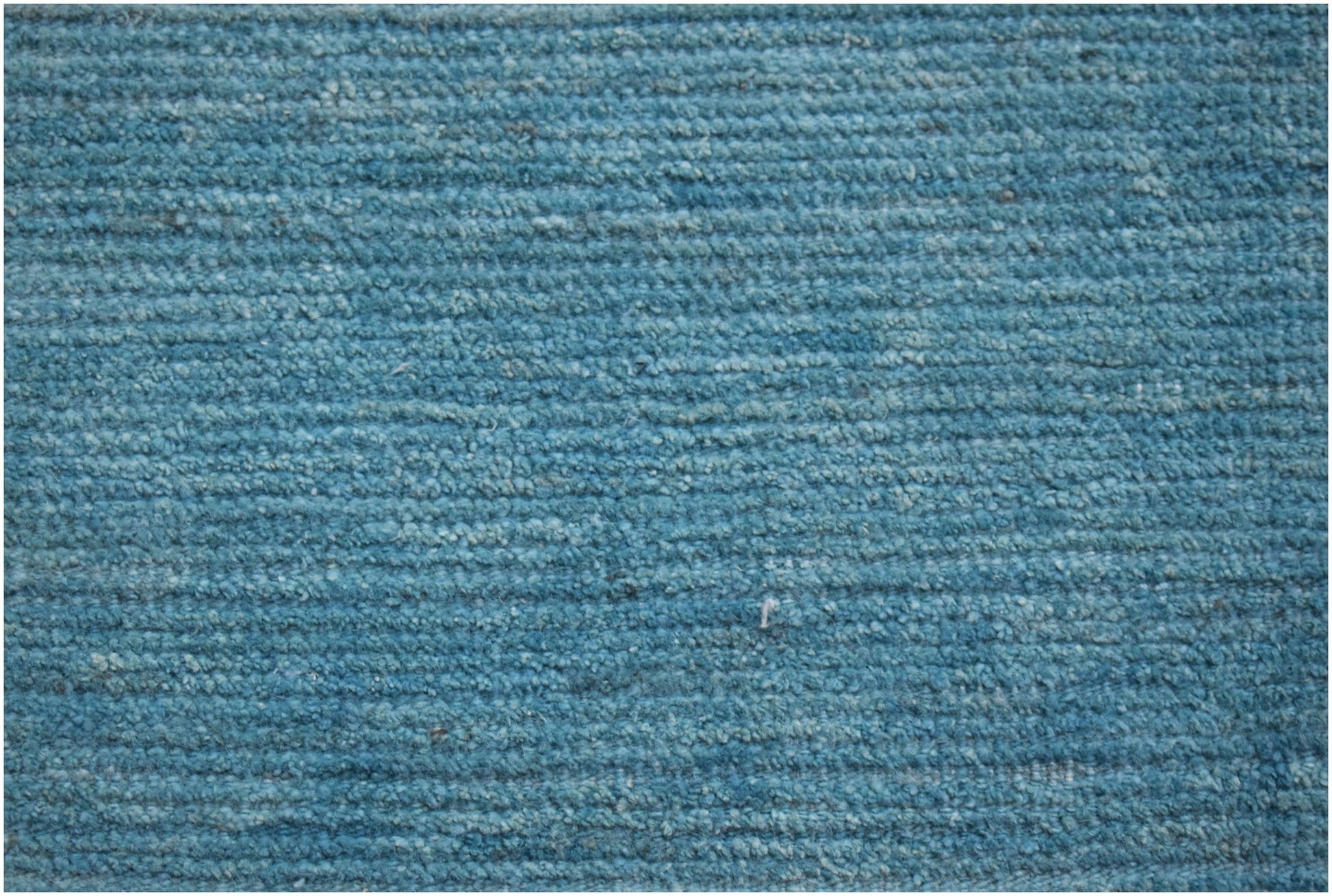 A hand-knotted Afghan Kohi rug featuring a textured, ribbed surface in a solid teal blue tone.