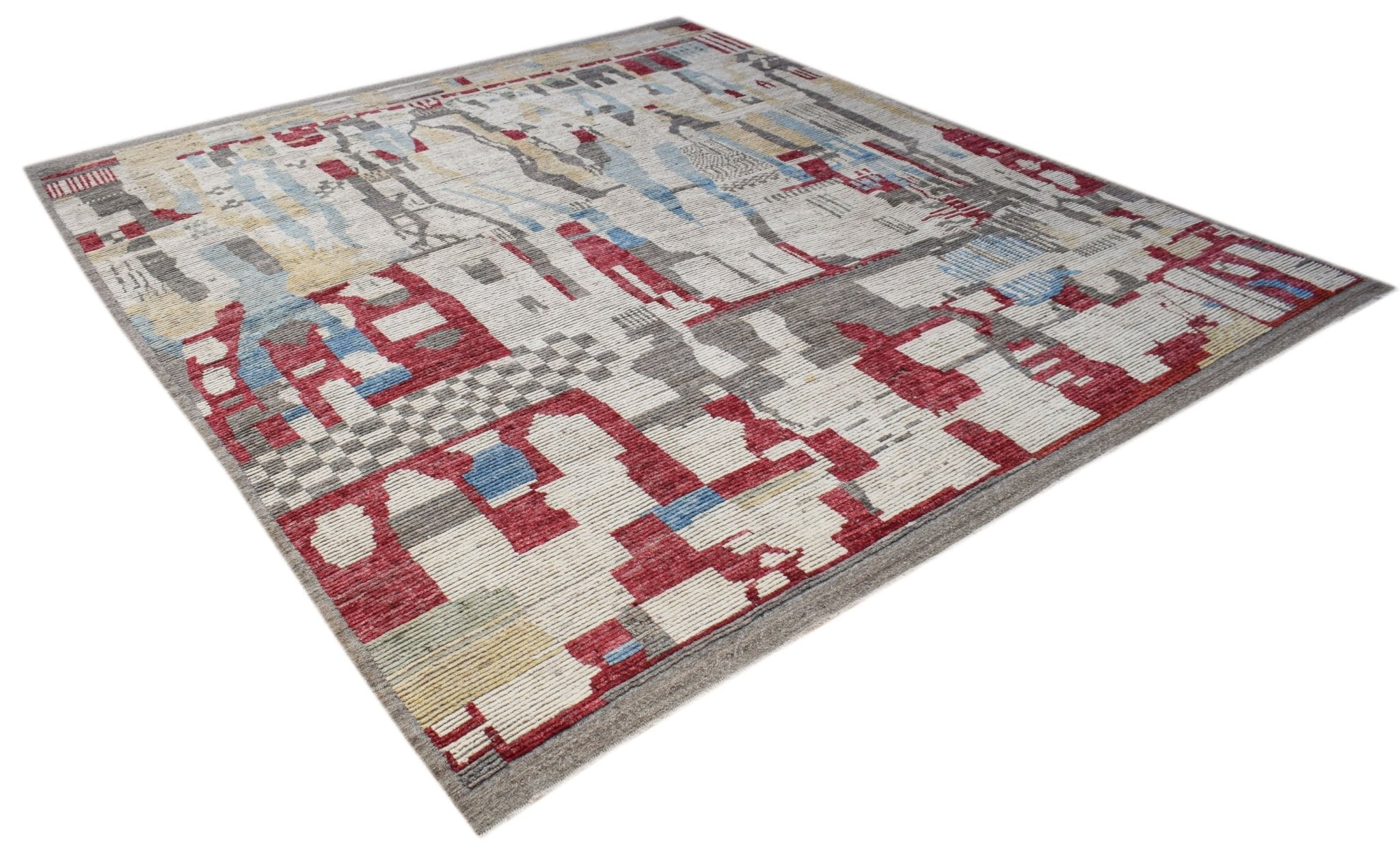 A hand-knotted Afghan rug featuring a geometric pattern in red, blue, and grey on a cream base.