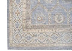 A handmade wool rug featuring a light blue and beige geometric Khotan pattern.