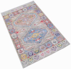 A handwoven transitional Oushak rug featuring a grey field with two colorful geometric medallions.