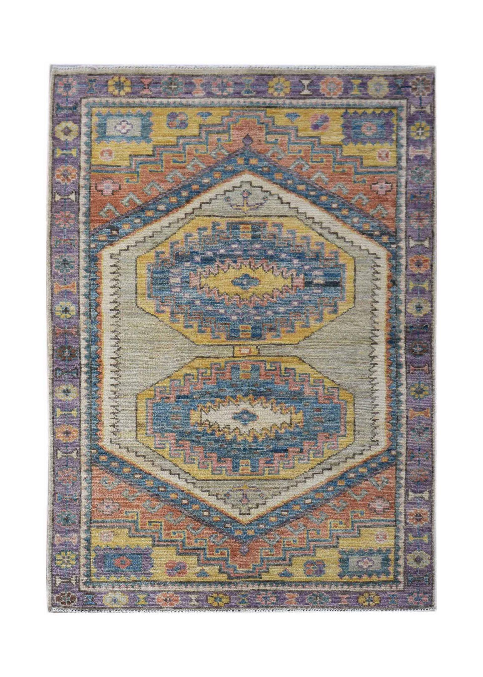 A handwoven wool Oushak rug featuring a geometric pattern in blue, yellow, and muted orange tones.