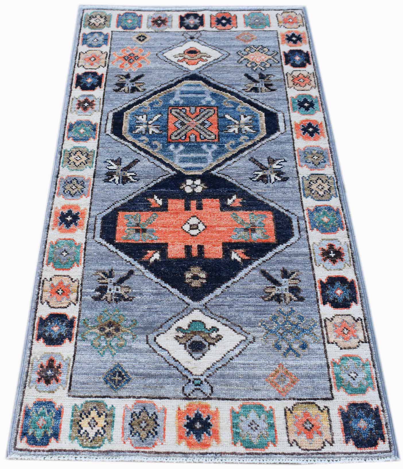 A handwoven transitional Oushak runner rug featuring geometric patterns in blue, orange, and cream.