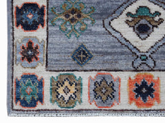A handwoven transitional Oushak rug featuring a blue field with geometric and floral motifs.