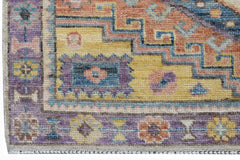 A handwoven transitional Oushak rug featuring a geometric floral pattern in vibrant colors.