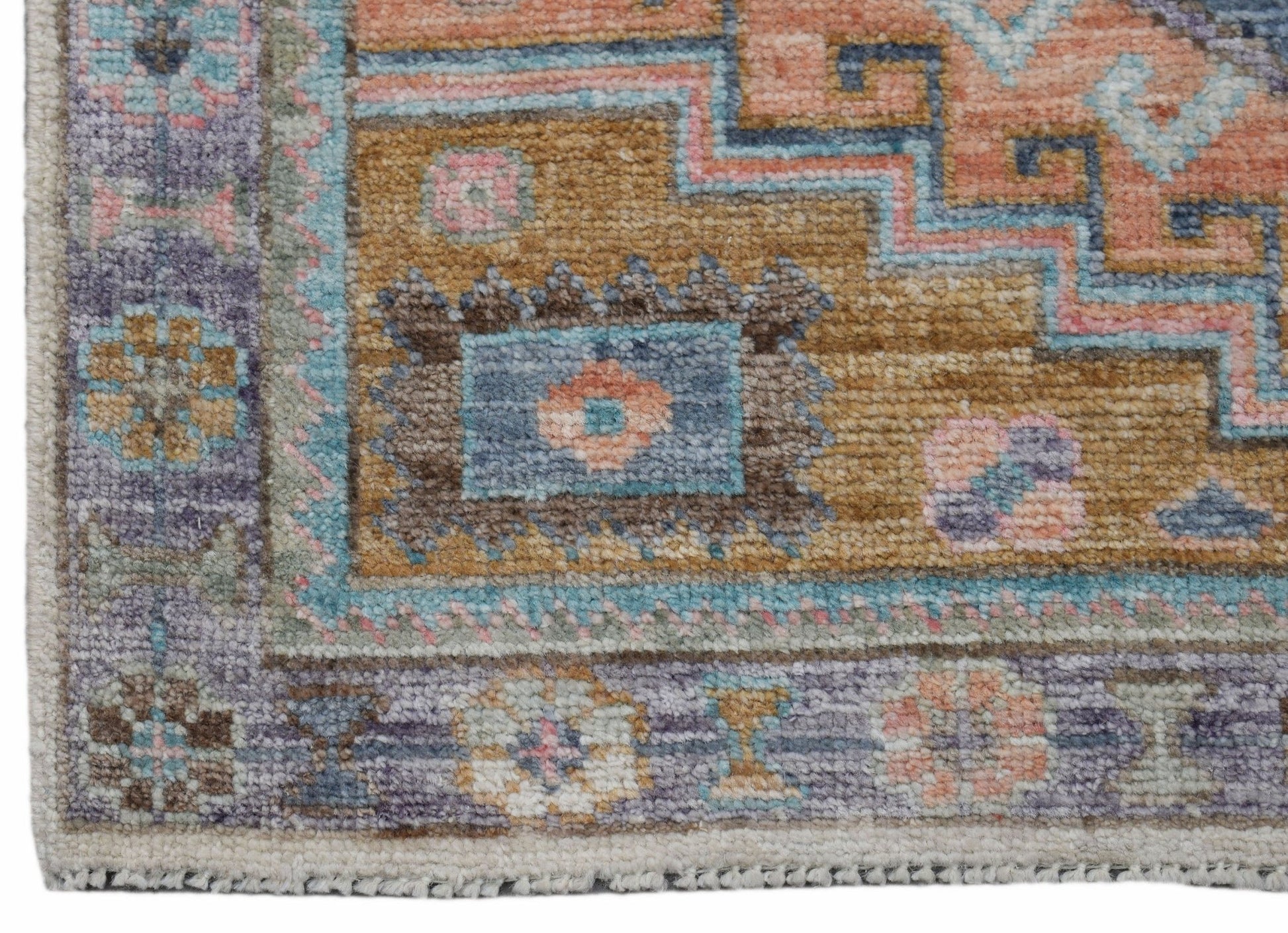A handwoven transitional Oushak rug featuring a floral pattern in muted tones of gold, blue, and pink.