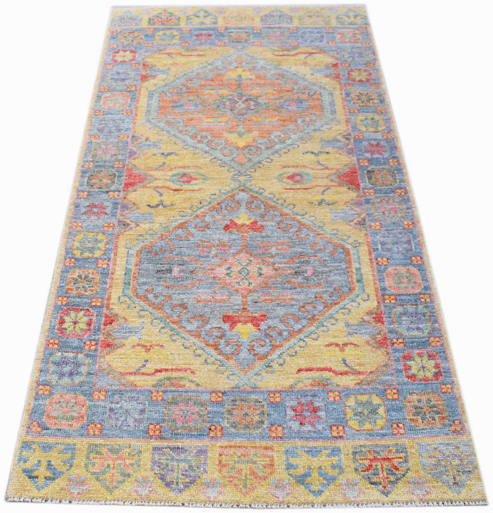A handwoven transitional Oushak rug featuring a floral pattern in blue, yellow, and orange tones.