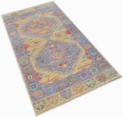 A handwoven transitional Oushak rug featuring a floral pattern in blue, yellow, and red tones.