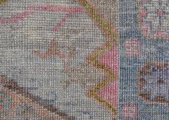 A close-up view of a handwoven wool rug featuring a transitional floral pattern in soft colors.