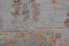 A close-up view of a handwoven transitional Oushak rug featuring a textured wool pile.