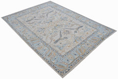 A handwoven transitional Oushak rug featuring a floral pattern in soft blue and beige tones.