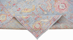 A handwoven transitional Oushak rug in light blue with floral patterns in pink and yellow.