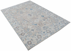 A handwoven transitional Oushak rug featuring a floral pattern in muted blue and beige tones.