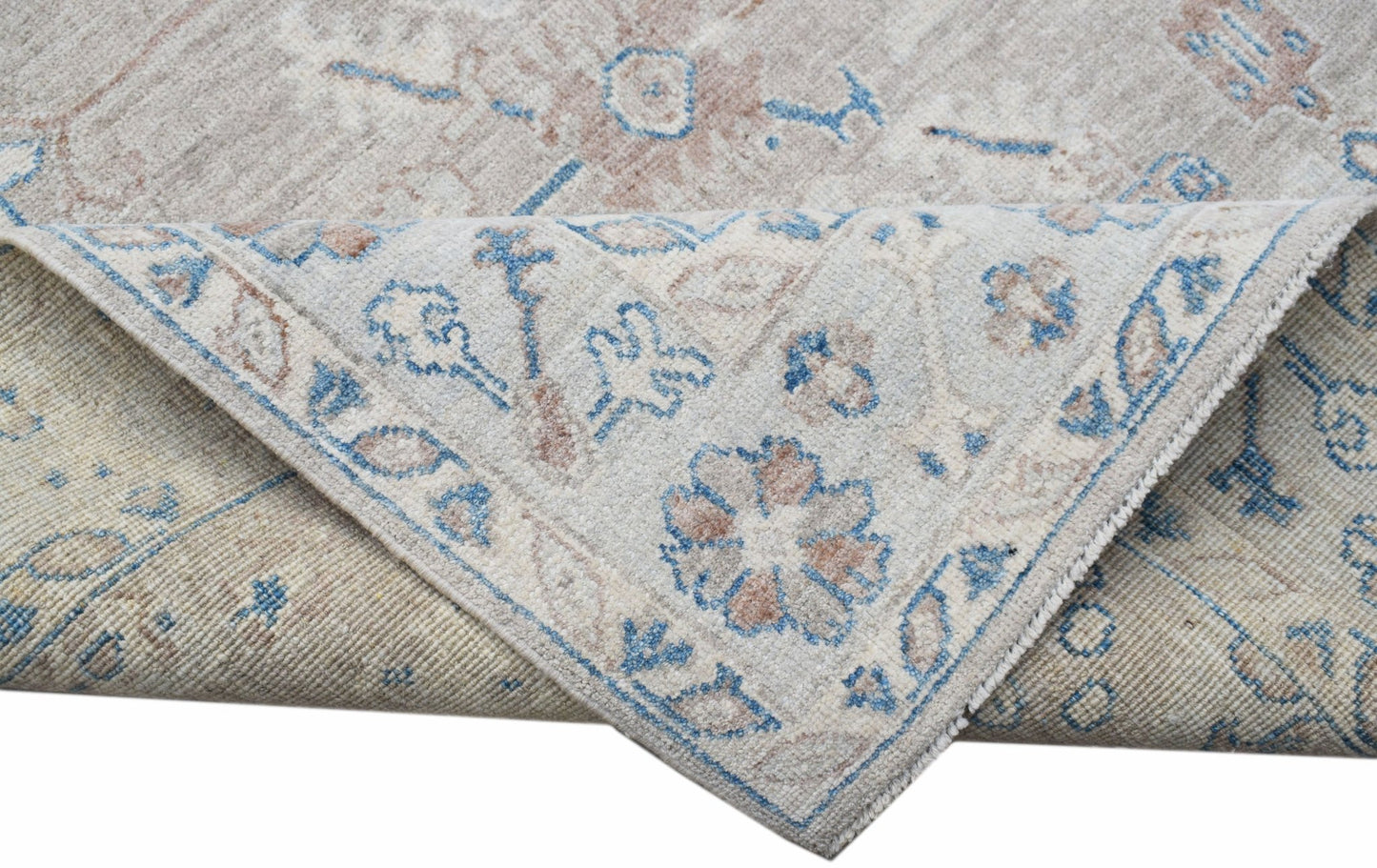 A handwoven transitional Oushak rug featuring a floral pattern in blue and beige tones.