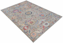 A handwoven transitional Oushak rug featuring a floral pattern in muted, multi-colored tones.