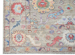 A handwoven transitional Oushak rug featuring a floral pattern in soft, multi-colored tones.