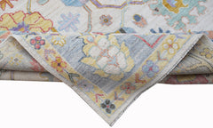 A handwoven transitional Oushak rug featuring a floral pattern in soft, contemporary colors.