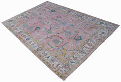 A handwoven transitional Oushak rug featuring a floral pattern in pink, blue, and yellow tones.