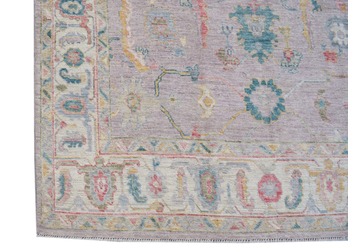 A handmade Afghan Oushak rug featuring a traditional floral pattern in soft pastel tones.