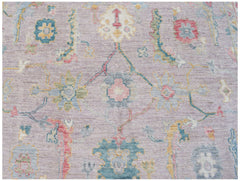 A handmade Afghan Oushak rug featuring a traditional floral pattern in soft pastel tones.