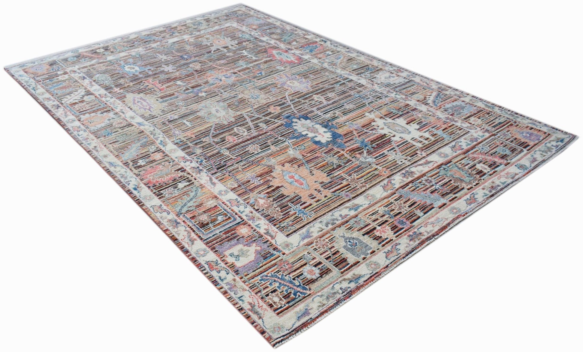 A handwoven transitional Oushak rug featuring a floral pattern in muted, contemporary colors.