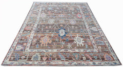 A handwoven transitional Oushak rug featuring a floral pattern in muted, multi-colored tones.