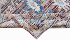 A handwoven transitional Oushak rug featuring a floral pattern in blue, red, and neutral tones.