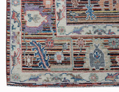 A handwoven transitional Oushak rug featuring a multi-colored floral pattern on a cream background.