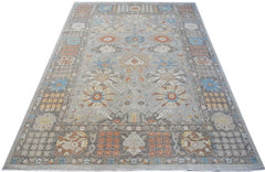 A handwoven transitional Oushak rug featuring a floral pattern in soft grey, blue, and orange tones.