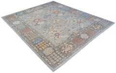 A handwoven transitional Oushak rug featuring a floral pattern in muted tones on a grey background.