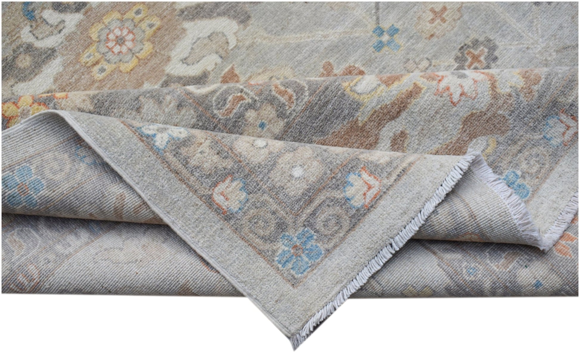 A handwoven transitional Oushak rug featuring a floral pattern in soft blue, grey, and tan tones.
