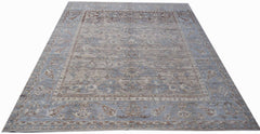 A handmade transitional Oushak rug featuring a soft blue and beige floral pattern.