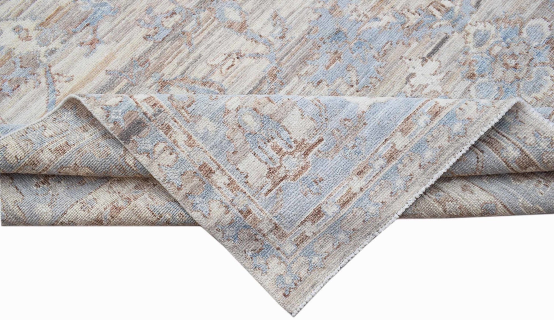 A handwoven transitional Oushak rug featuring a distressed pattern in shades of blue and beige.