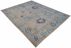 A handwoven transitional Oushak rug featuring a floral pattern in blue, yellow, and grey tones.