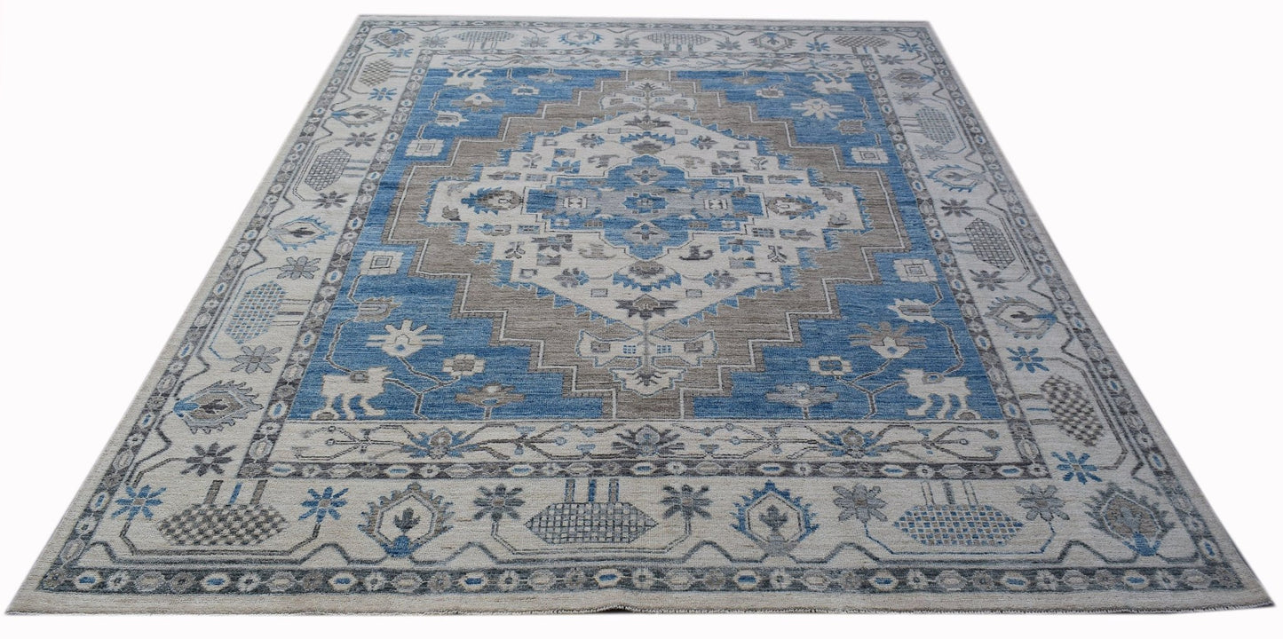 A rectangular transitional Oushak rug featuring a blue and beige geometric medallion pattern.