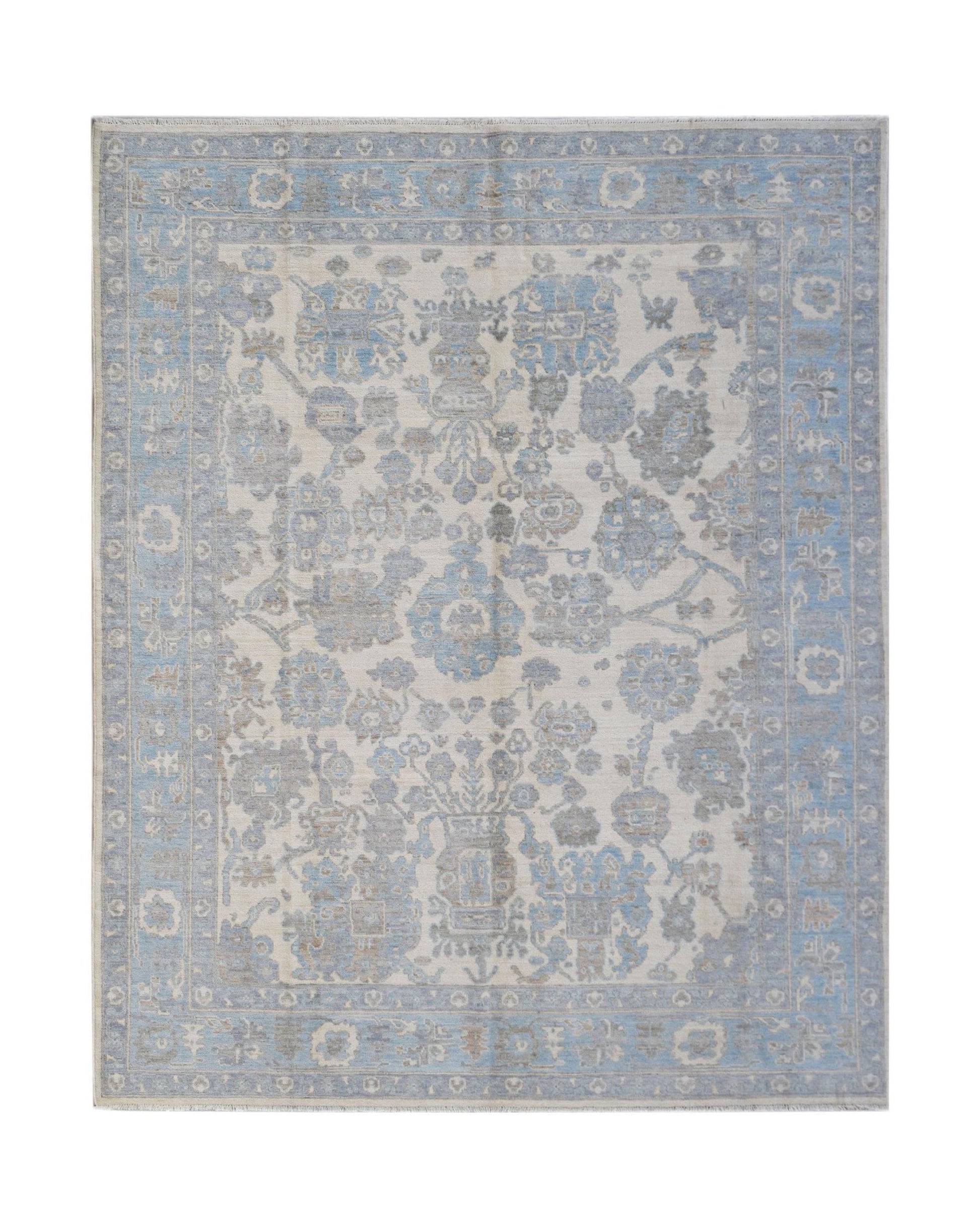 A handmade transitional Oushak rug featuring a soft blue and grey floral pattern on a cream base.