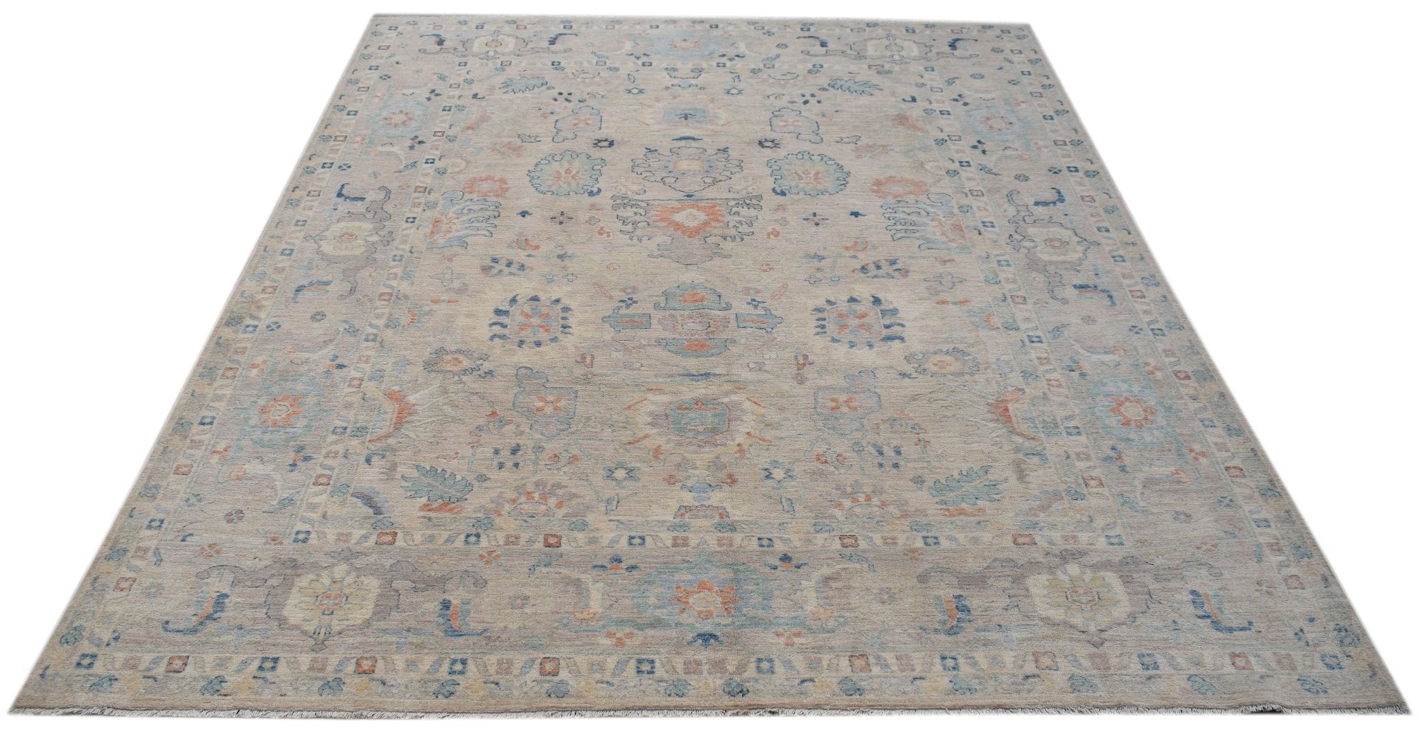 A handwoven transitional Oushak rug featuring a floral pattern in soft blue and orange tones.
