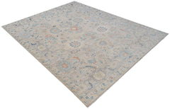 A handwoven transitional Oushak rug featuring a light floral pattern in soft blue and orange tones.