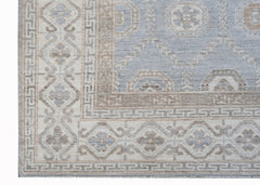A handwoven transitional Oushak rug featuring a light blue and beige geometric floral pattern.