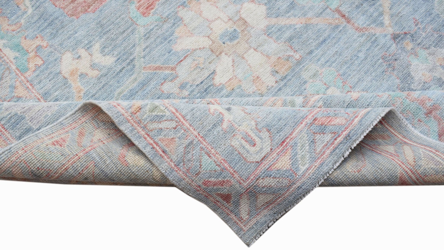 A handwoven transitional Oushak rug featuring a light blue floral pattern in hand-spun wool.