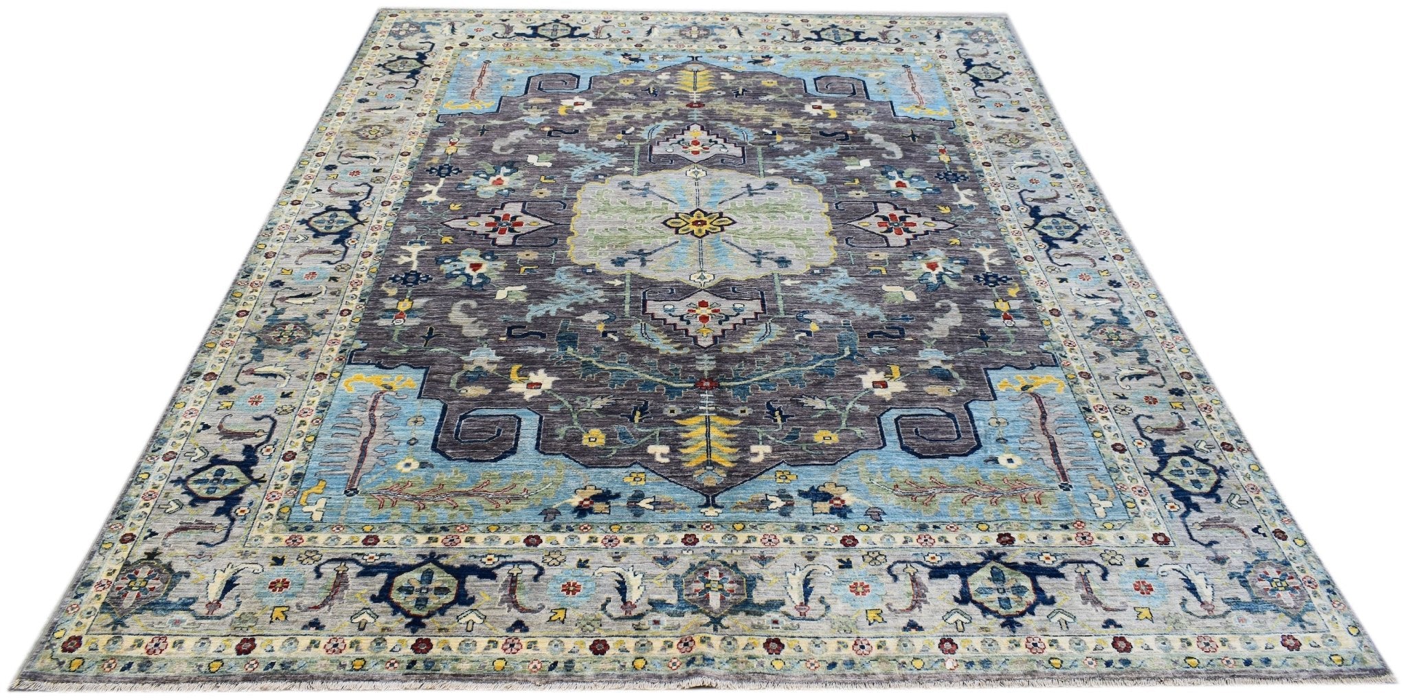 A handwoven transitional Oushak rug featuring a floral pattern in blue, grey, and yellow tones.