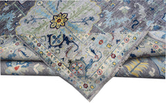 A handwoven transitional Oushak rug featuring a floral pattern in blue, grey, and yellow tones.