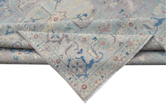 A handwoven transitional Oushak rug featuring a floral pattern in soft blue and grey tones.