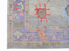A handwoven transitional Oushak rug featuring a floral pattern in purple, grey, and red tones.