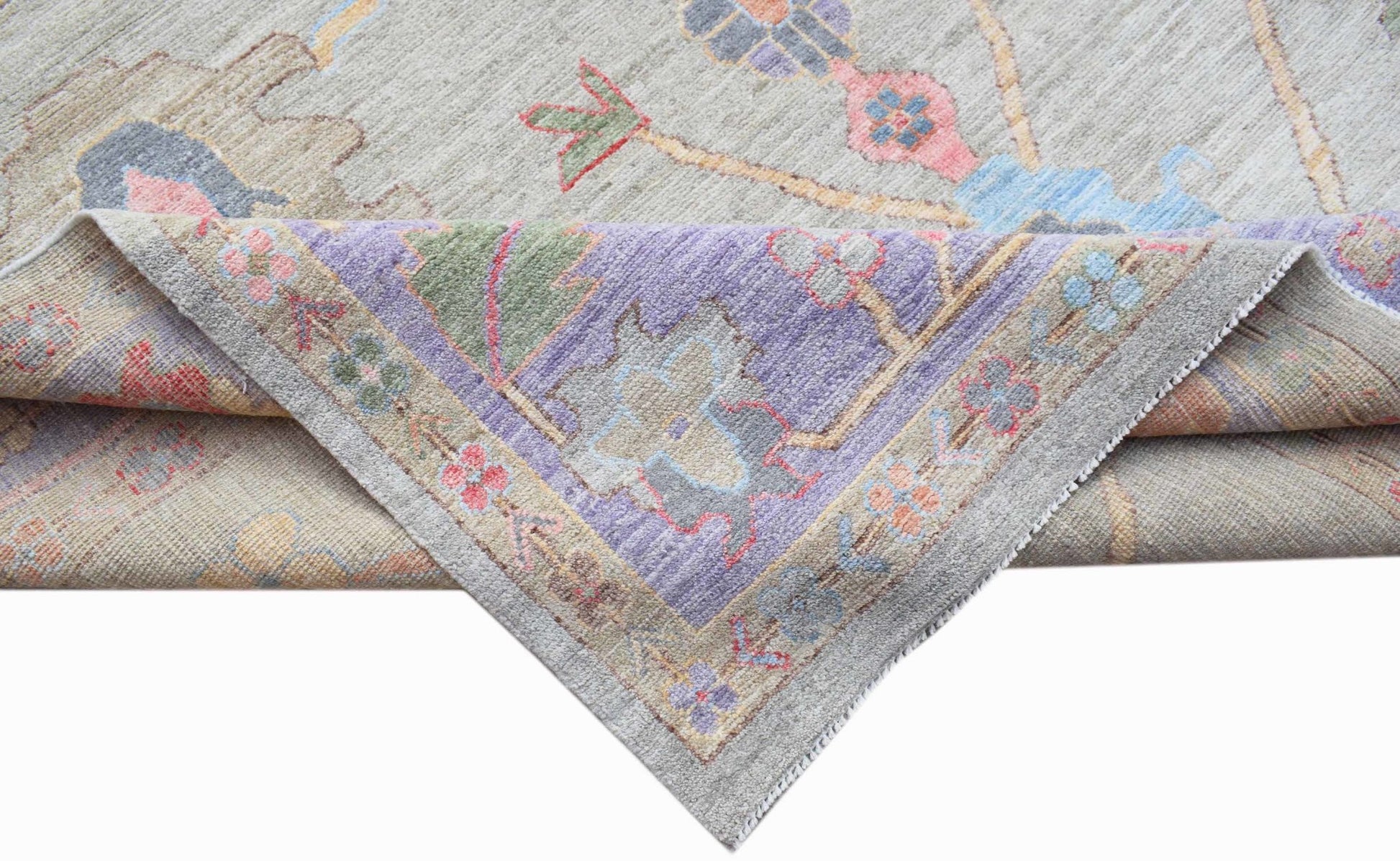A handwoven transitional Oushak rug with a floral pattern in soft, contemporary colors.